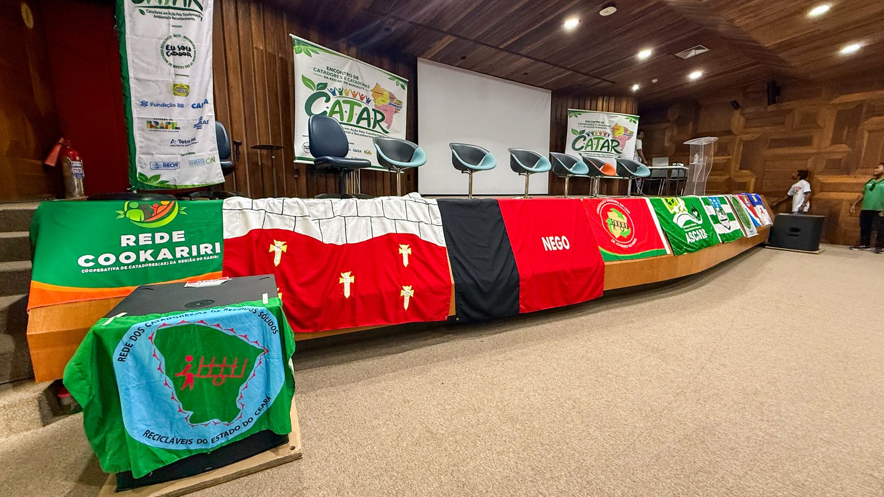 Bandeiras das organizações dos estados do Nordeste na mesa do palco
