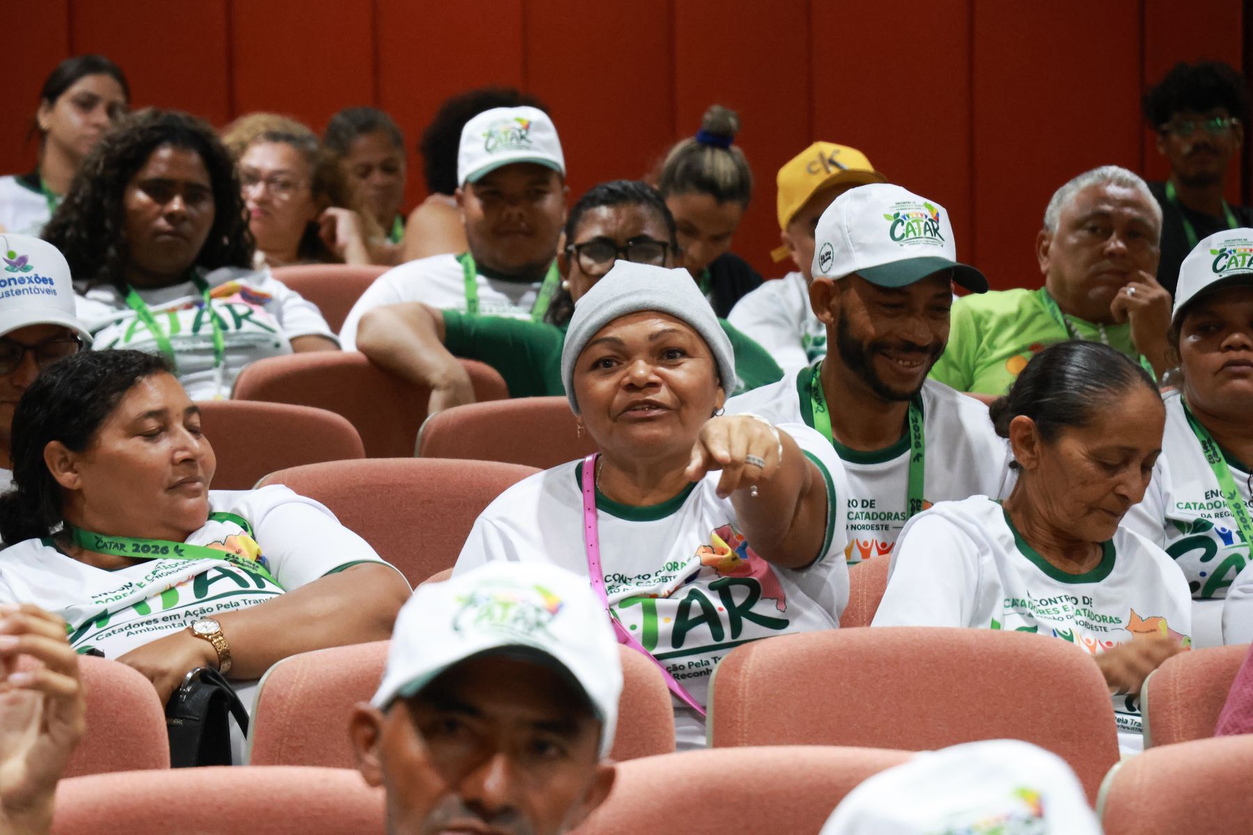 Plateia animada com bonés e camisetas do CATAR