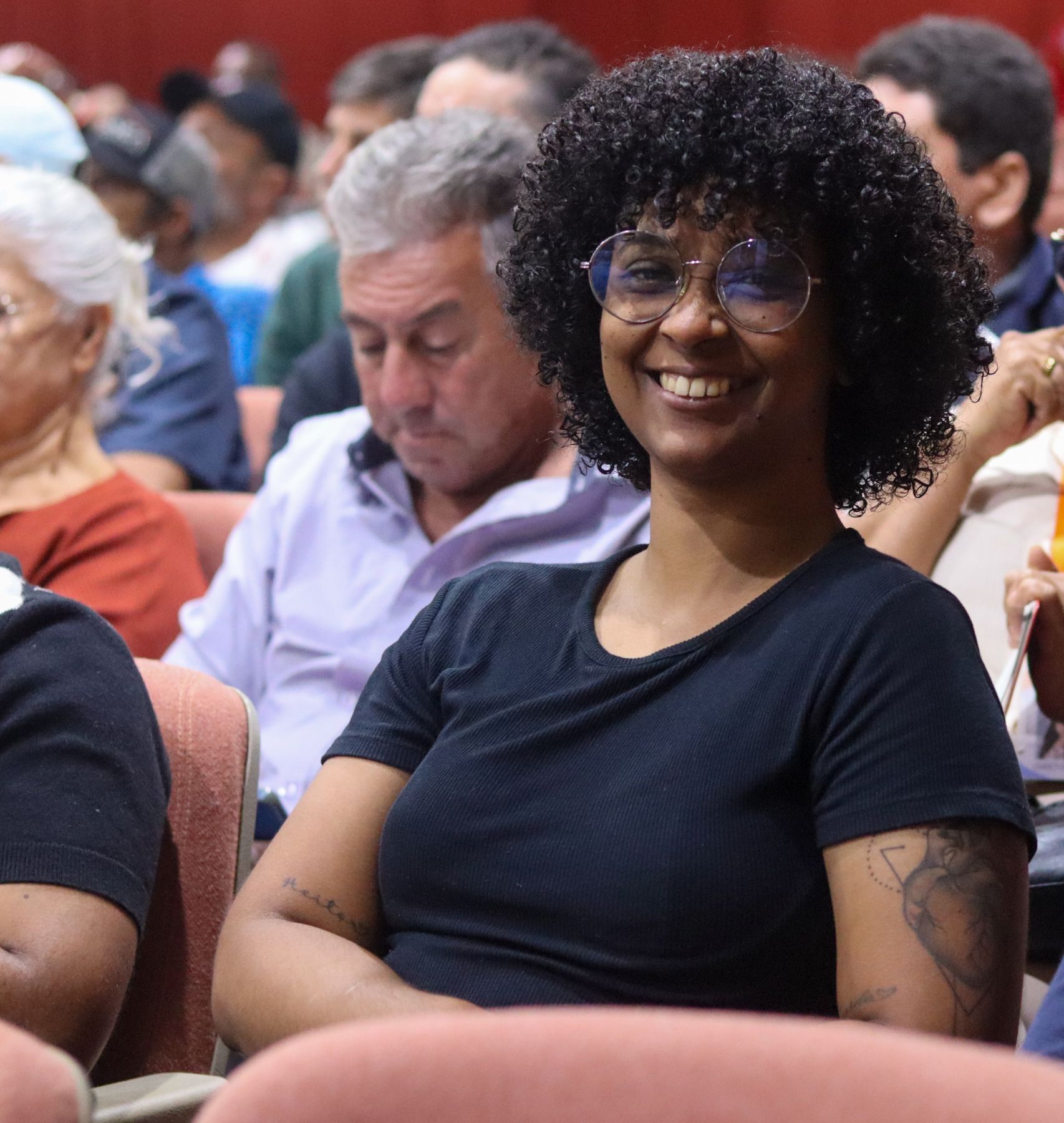 Participante sorri na plateia do encontro