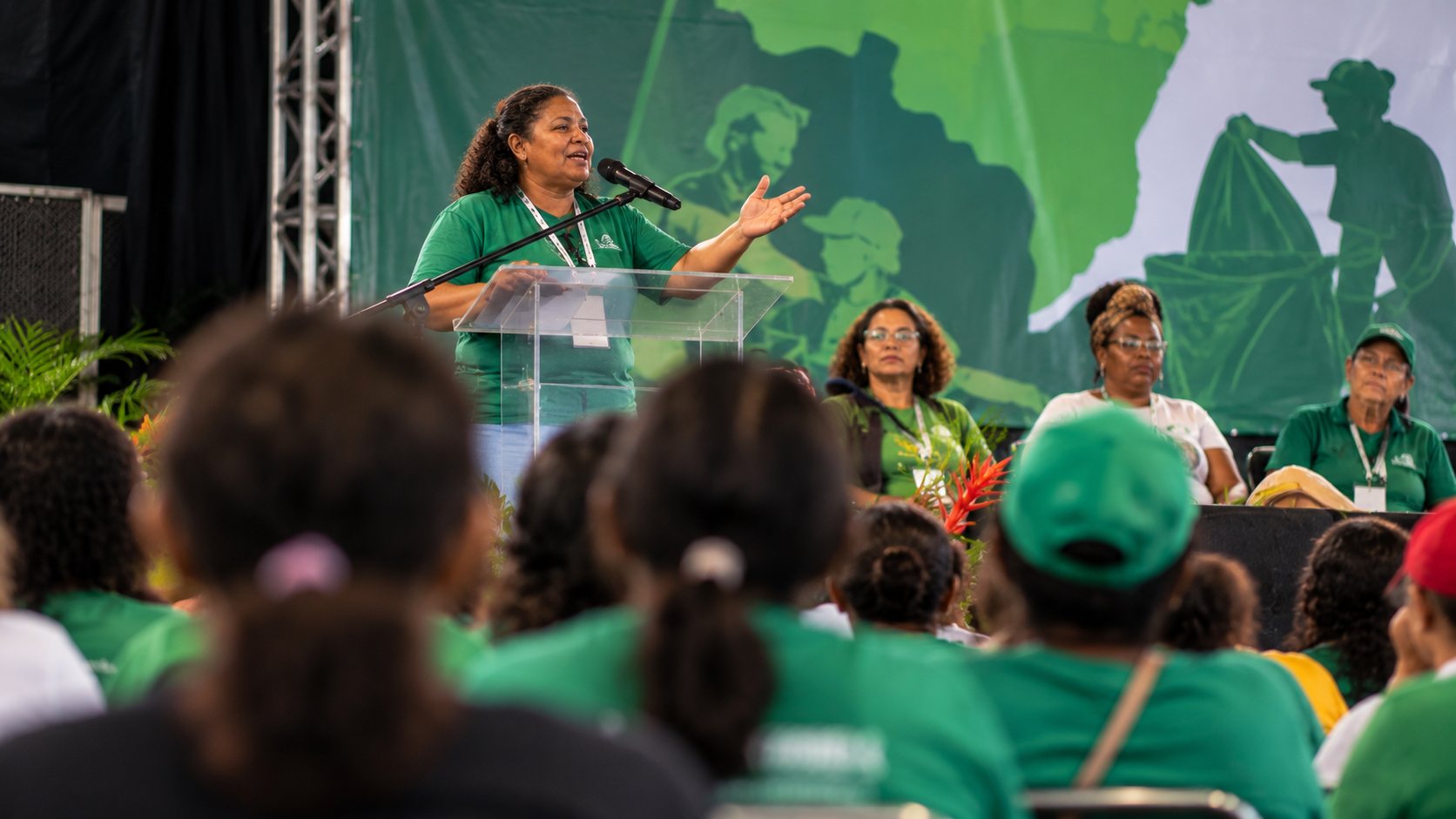 Liderança discursa no palco do encontro