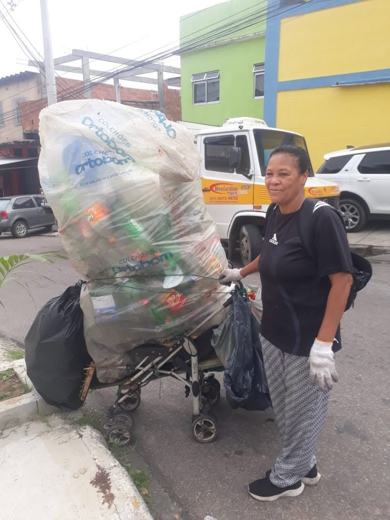 Catadora com carrinho carregado de recicláveis na rua