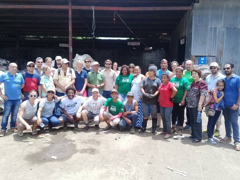 Catadoras, catadores e apoiadores reunidos em frente a um galpão de reciclagem