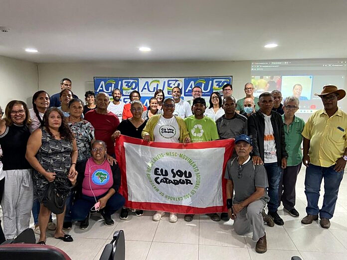 Catadoras e catadores reunidos com a bandeira do Movimento Eu Sou Catador